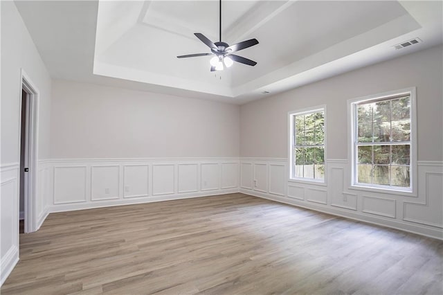 5096 Limerick Ln, Flowery Branch, GA 30542 - unfurnished room with a raised ceiling, light wood finished floors, ceiling fan, wainscoting, and a decorative wall