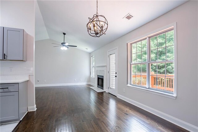 5096 Limerick Ln, Flowery Branch, GA 30542 - unfurnished living room featuring dark wood-style flooring, a chandelier, lofted ceiling, baseboards, and a fireplace with raised hearth