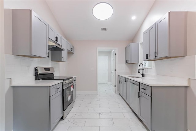 5096 Limerick Ln, Flowery Branch, GA 30542 - kitchen with appliances with stainless steel finishes, a sink, gray cabinets, light marble finish floors, and under cabinet range hood