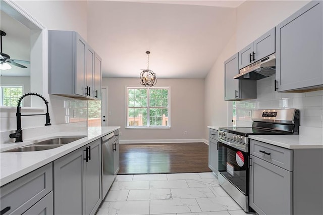 5096 Limerick Ln, Flowery Branch, GA 30542 - kitchen with stainless steel appliances, a sink, gray cabinets, light countertops, and vaulted ceiling