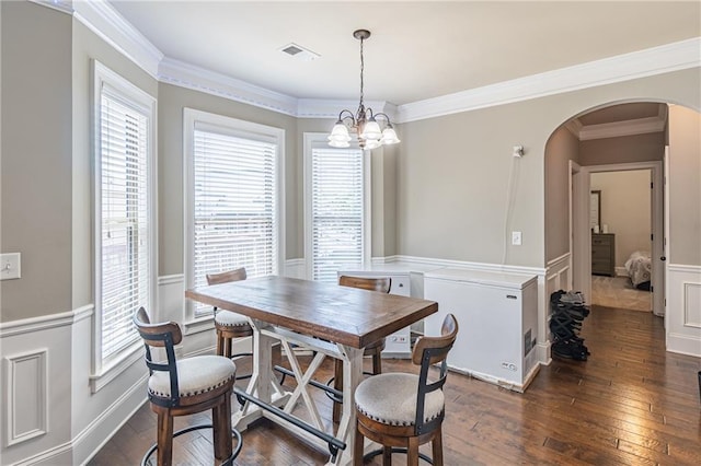2183 Trinity Grove Ct, Dacula, GA 30019 - dining area featuring arched walkways, dark wood-style flooring, a wainscoted wall, a chandelier, and ornamental molding