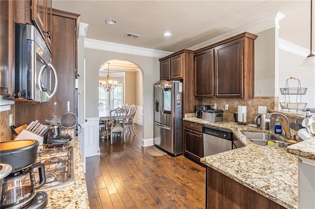 2183 Trinity Grove Ct, Dacula, GA 30019 - kitchen with stainless steel appliances, arched walkways, dark wood finished floors, light stone counters, and crown molding