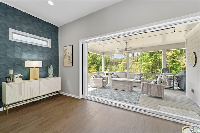 doorway to outside featuring an accent wall, baseboards, ceiling fan, wood finished floors, and wallpapered walls
