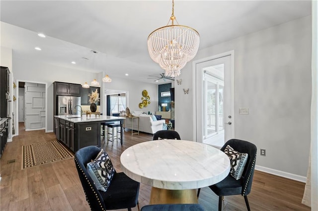 dining room with a chandelier, dark wood finished floors, baseboards, and recessed lighting
