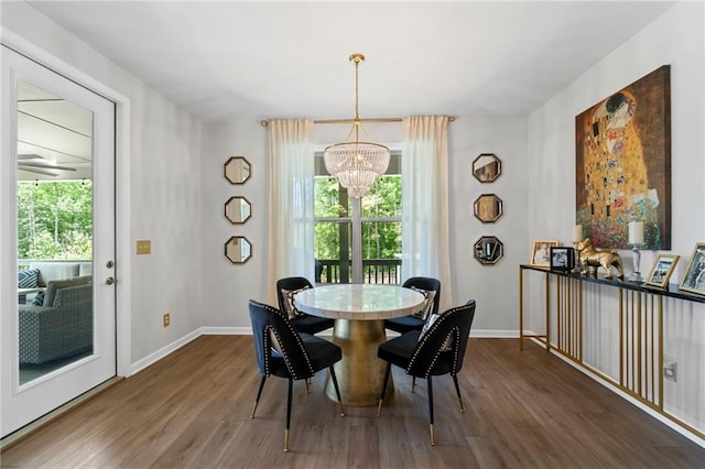 dining space with a chandelier, wood finished floors, plenty of natural light, and baseboards