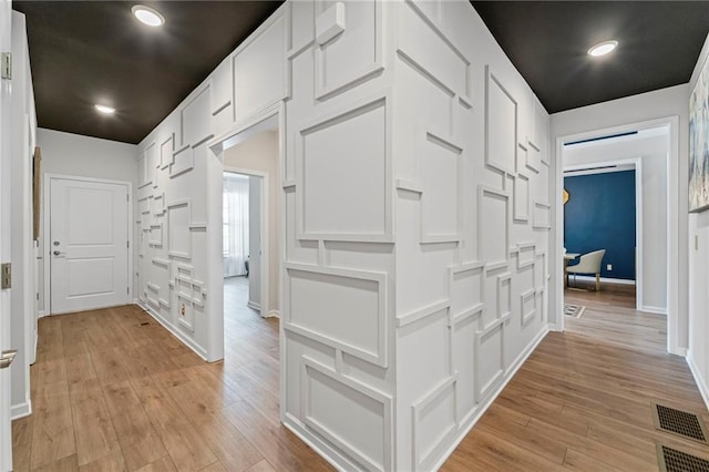 corridor featuring light wood-style floors and baseboards
