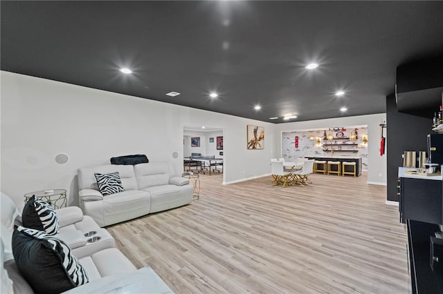 living room with light wood finished floors, baseboards, and recessed lighting