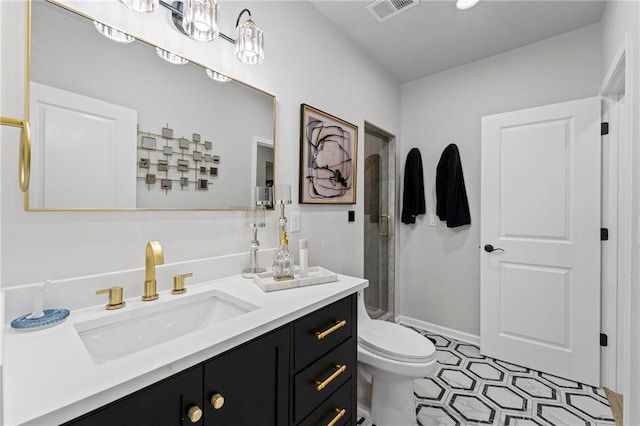 bathroom featuring vanity, toilet, a stall shower, and tile patterned floors