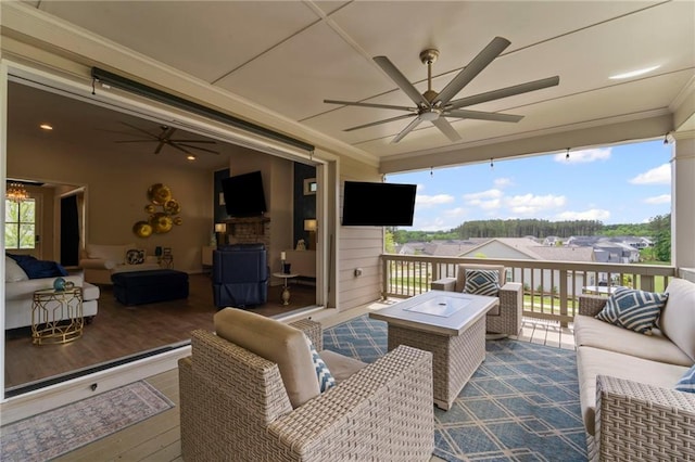 wooden terrace with an outdoor hangout area and a ceiling fan