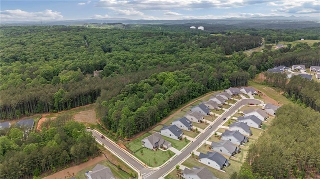 view of property location featuring a heavily wooded area and nearby suburban area
