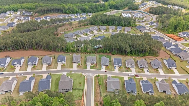 aerial view of property's location with nearby suburban area and a heavily wooded area