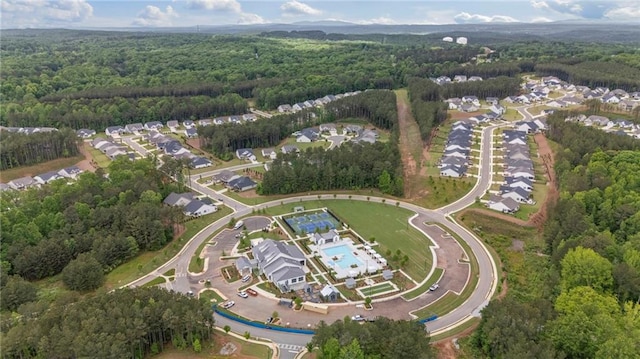 view of property location featuring a forest and a pool area