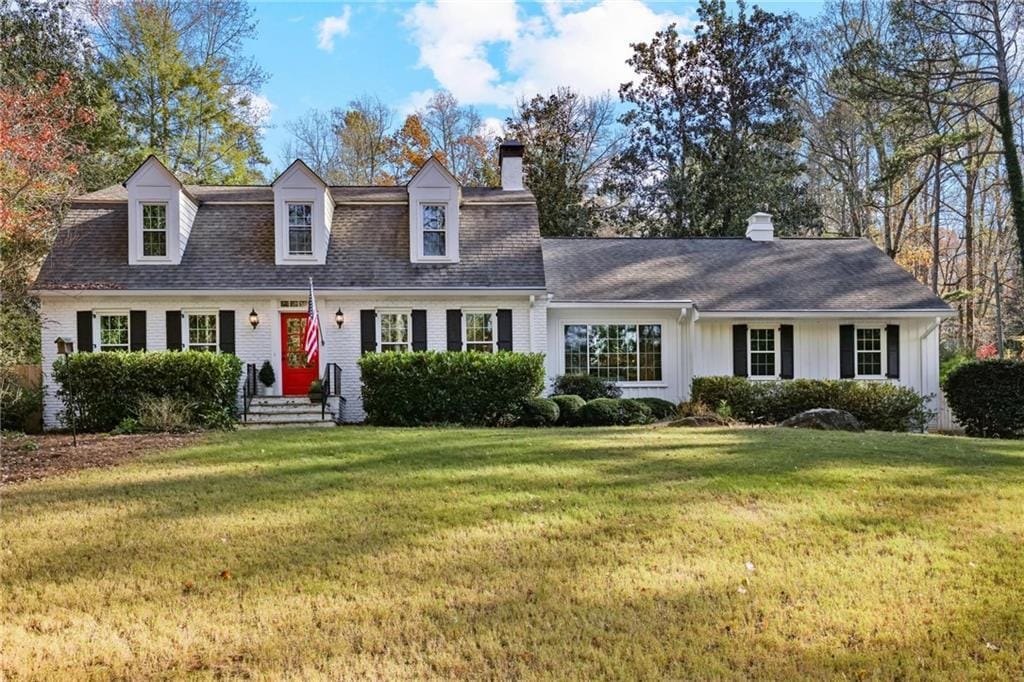 cape cod-style house featuring a front lawn