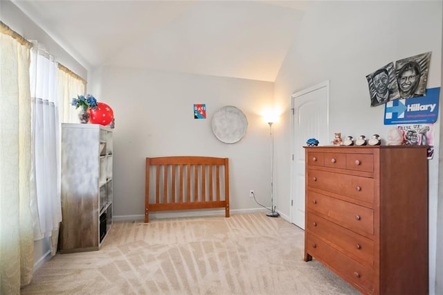 bedroom with lofted ceiling, light carpet, and baseboards