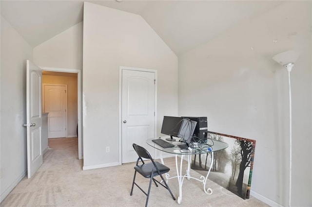 carpeted office with lofted ceiling and baseboards