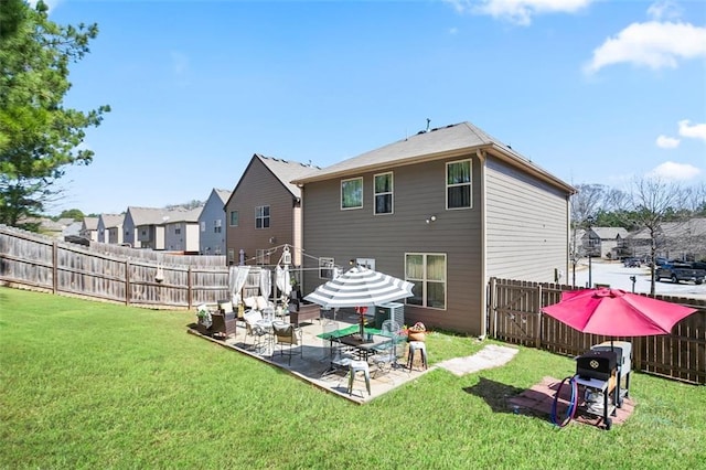 back of house with a lawn, a patio area, and a fenced backyard