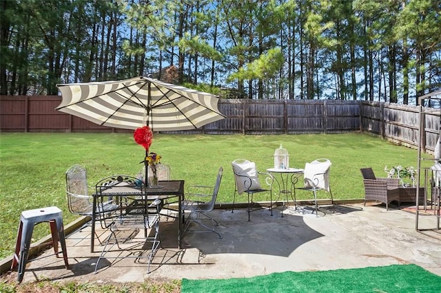 view of yard featuring outdoor dining space, a patio area, and a fenced backyard