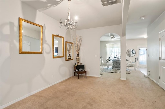 interior space featuring arched walkways, a notable chandelier, light colored carpet, visible vents, and baseboards