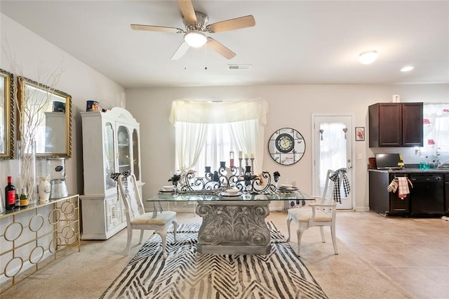 dining space featuring light carpet, ceiling fan, and visible vents