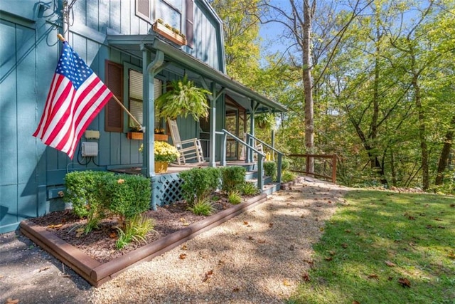 view of property exterior with a porch and a lawn