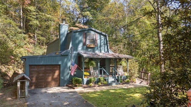 view of front of property featuring a porch, a garage, and a front lawn