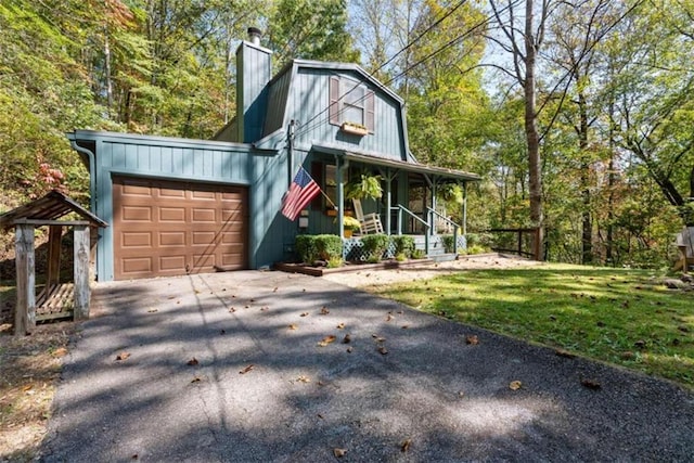 view of front of home featuring a front lawn, a porch, and a garage