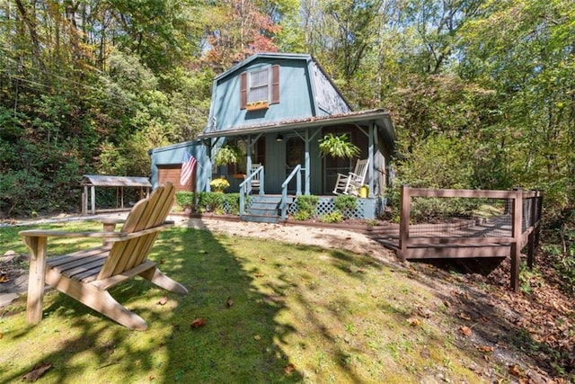 rear view of house featuring a lawn and covered porch