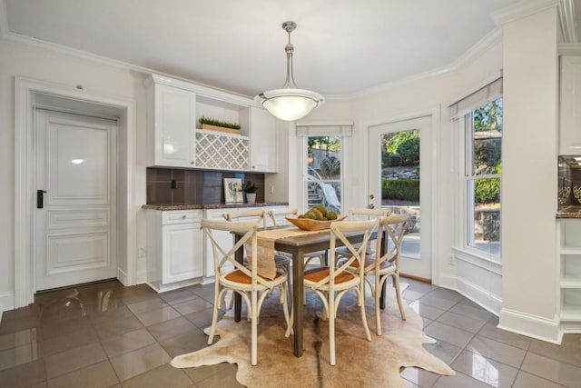 tiled dining room featuring ornamental molding