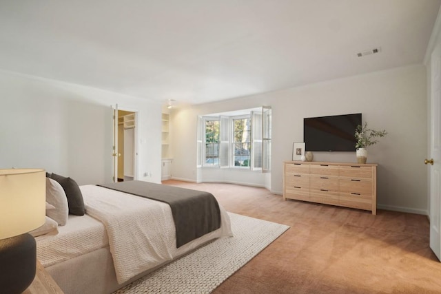 carpeted bedroom featuring a spacious closet and a closet