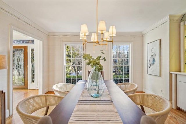 dining space with a notable chandelier, light wood-type flooring, and crown molding