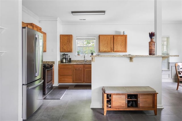 747 Dill Ave SW, Atlanta, GA 30310 - kitchen featuring freestanding refrigerator, brown cabinetry, a sink, range with gas cooktop, and ornamental molding