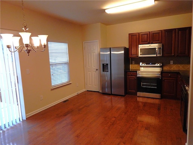 2199 Landing Walk Dr, Duluth, GA 30097 - kitchen with stainless steel appliances, a chandelier, dark wood-style flooring, decorative light fixtures, and decorative backsplash