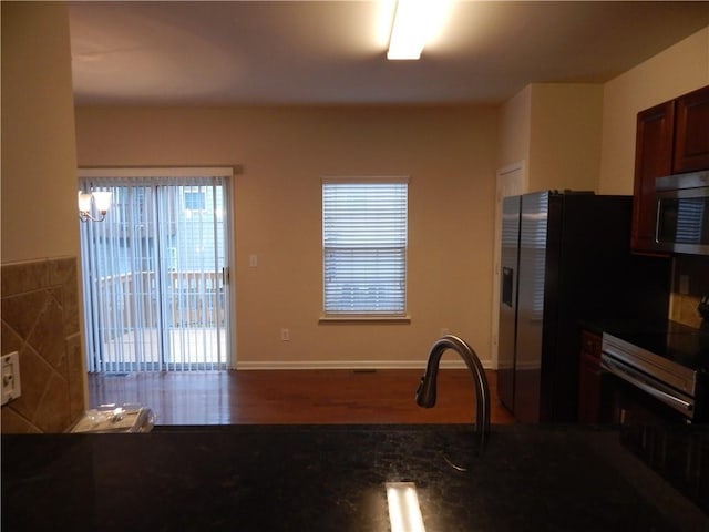 2199 Landing Walk Dr, Duluth, GA 30097 - kitchen with stainless steel microwave, dark countertops, healthy amount of natural light, and wood finished floors