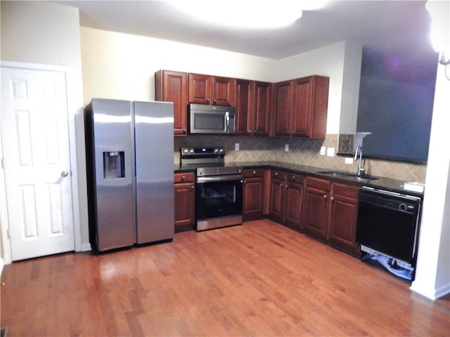 2199 Landing Walk Dr, Duluth, GA 30097 - kitchen featuring appliances with stainless steel finishes, dark countertops, backsplash, and light wood-style flooring