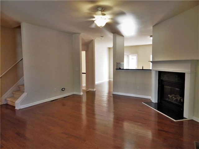 2199 Landing Walk Dr, Duluth, GA 30097 - unfurnished living room with ceiling fan, a glass covered fireplace, wood finished floors, and stairway