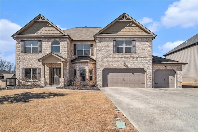 craftsman-style house featuring driveway, brick siding, and a front yard