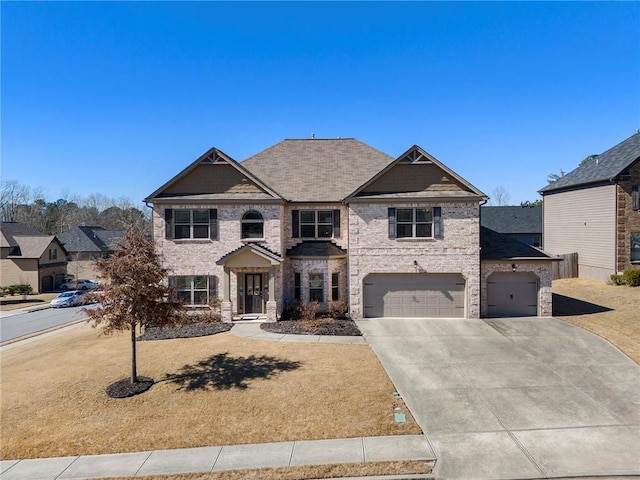 view of front of property featuring driveway, a front lawn, an attached garage, and brick siding