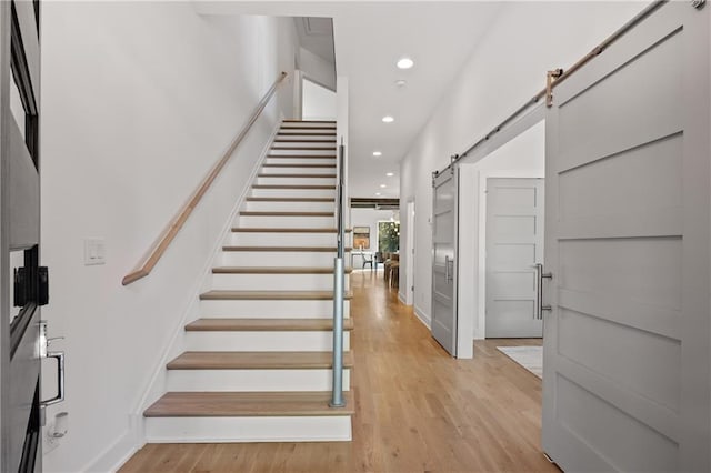 stairway featuring hardwood / wood-style floors and a barn door