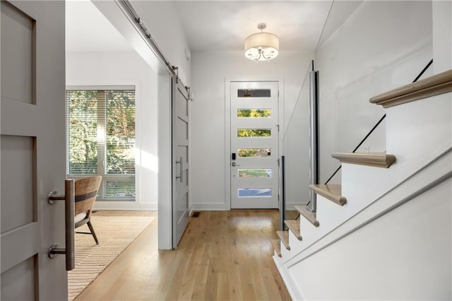 doorway to outside with light hardwood / wood-style flooring and a barn door