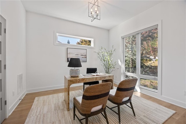 office area featuring light hardwood / wood-style floors and a chandelier