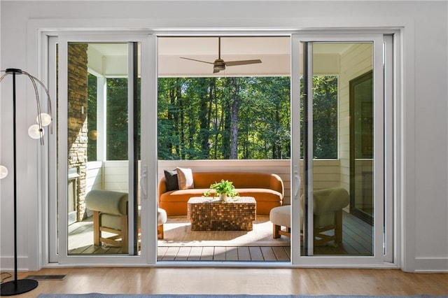 doorway to outside with ceiling fan, light hardwood / wood-style floors, and a wealth of natural light