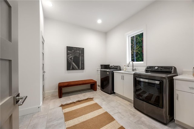 laundry area featuring sink, cabinets, and light tile patterned floors