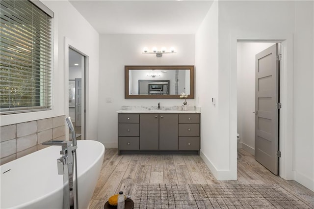 bathroom with vanity, hardwood / wood-style flooring, a tub, and toilet