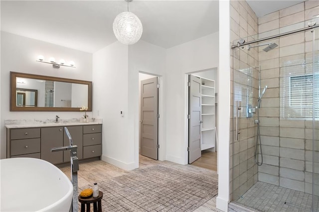 bathroom with hardwood / wood-style flooring, vanity, and independent shower and bath