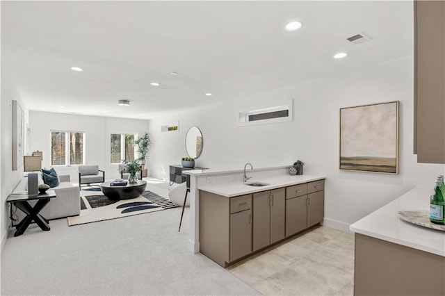 kitchen featuring kitchen peninsula, sink, and light carpet