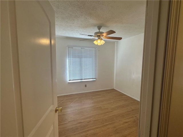 spare room with ceiling fan, a textured ceiling, and light hardwood / wood-style floors