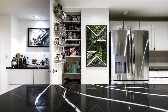 130 26th St NW Unit 701, Atlanta, GA 30309 - kitchen featuring stainless steel fridge, white cabinetry, and dark countertops