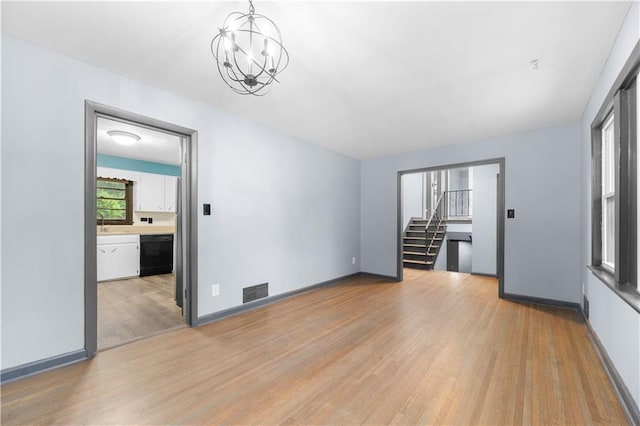 3664 Pin Oak Cir, Atlanta, GA 30340 - empty room with light wood-style floors, a chandelier, stairs, baseboards, and a sink