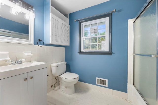 3664 Pin Oak Cir, Atlanta, GA 30340 - bathroom with toilet, vanity, combined bath / shower with glass door, tile patterned floors, and tile walls