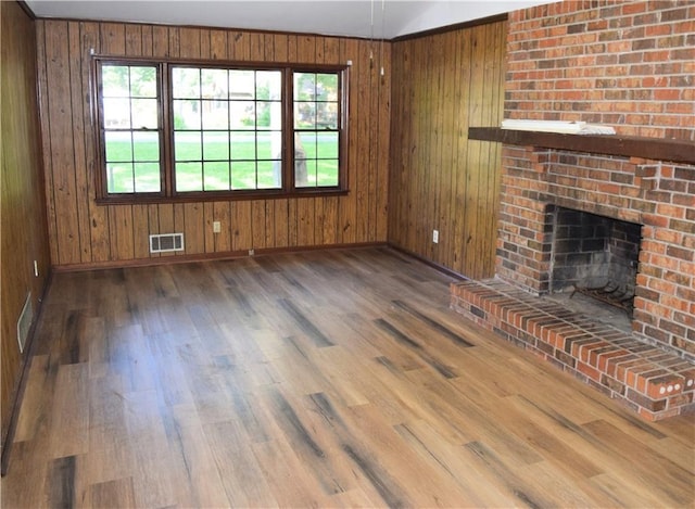 157 Sequoyah Cir, Canton, GA 30115 - unfurnished living room featuring baseboards, a fireplace, wooden walls, and wood finished floors